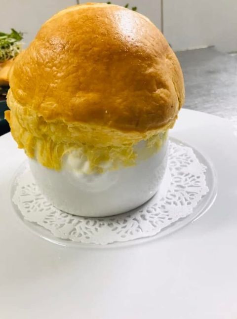 La montgolfière feuilletée : dôme de pâte dorée servi en cocotte blanche sur napperon de dentelle