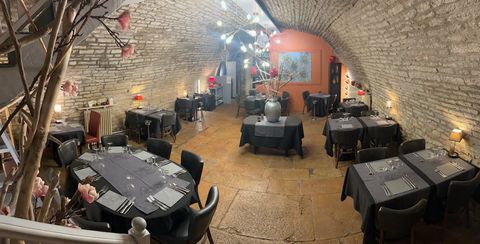 La cave voûtée en pierre du restaurant, dressée pour un repas de groupe